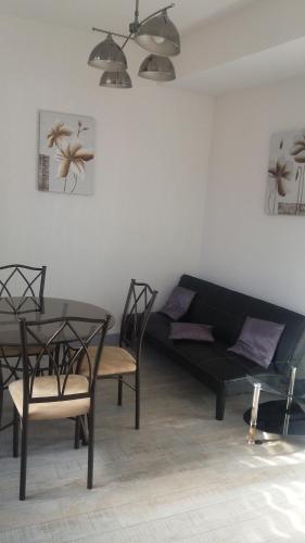 a living room with a couch and a table and chairs at Gîtes Macarien in Saint-Macaire