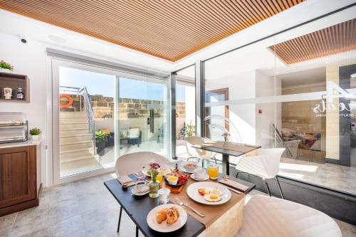 a dining room with a table with food on it at C4 Retreats Gozo in Xagħra