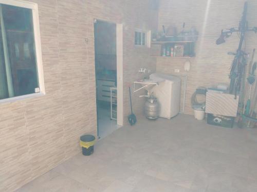 ein Raum mit einer Küche mit Kühlschrank und einer Tür in der Unterkunft Home Sweet Home Gravatá in Gravatá