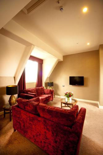 a living room with red couches and a tv at The Grand, York in York