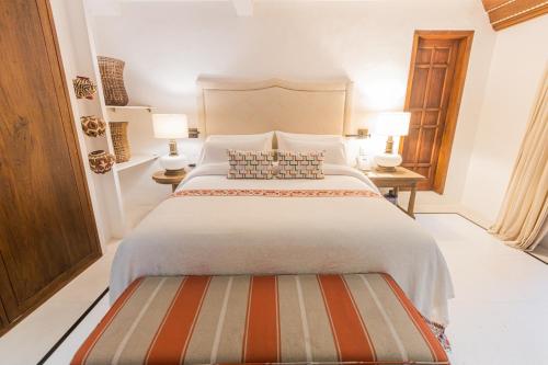 a bedroom with a large bed and two lamps at Casa de la Renta By Mustique in Cartagena de Indias