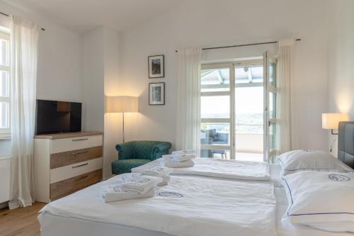 una camera da letto bianca con due letti e una televisione di Villa Casa Katharina a Vižinada