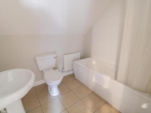 a bathroom with a toilet and a tub and a sink at St Michael's in Muff