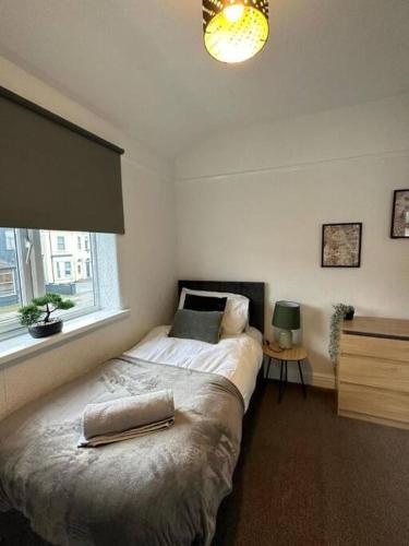 ウォリントンにあるSpacious 4Bedroom House in Warrington - Sleeps 8のベッドと窓のある寝室