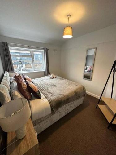 a bedroom with a bed and a couch and a window at Spacious 4Bedroom House in Warrington - Sleeps 8 in Warrington