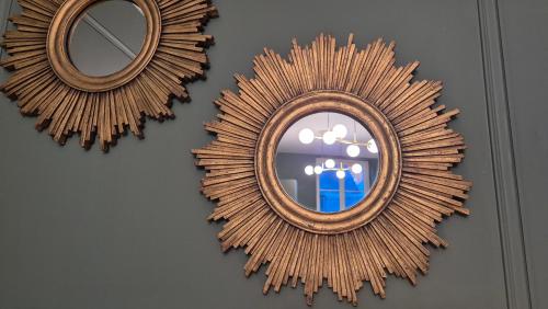 un miroir sur un mur avec deux miroirs sur lui dans l'établissement Appartement Le Napoléon Rouen Hypercentre, à Rouen