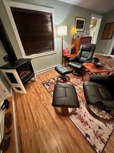 a living room with a fireplace and chairs and a television at Eagle Way in Port Renfrew