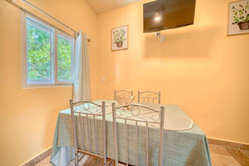 a bedroom with a bed with a table and a window at Caribe Tesoro in West Bay