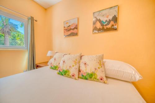 a bedroom with a bed with two pillows and a window at Caribe Tesoro in West Bay
