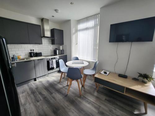a kitchen with a table and chairs in a room at Bright City Apt - King Bed - Parking & Wi-Fi in Dundee