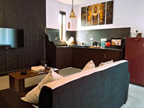 a living room with a couch and a kitchen at Arambol Bliss Hotel Apartments in Arambol
