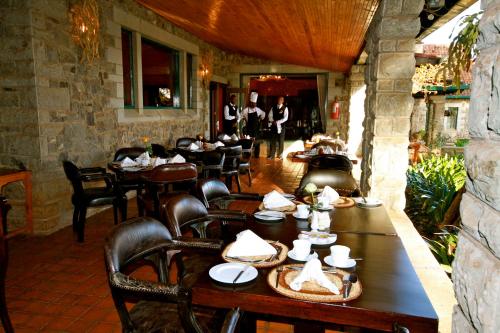 a restaurant with tables and chairs and people in the background at The Aberdare Country Club in Mweiga