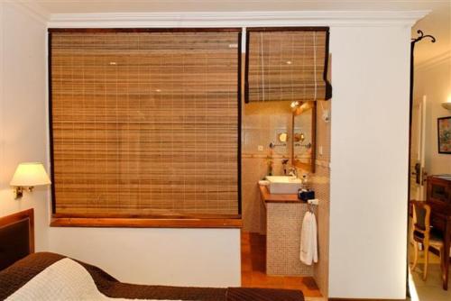 Baño con ventana con lavabo y espejo en Hotel Brajas, en Antananarivo