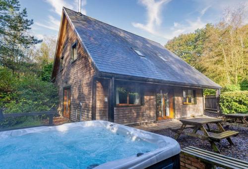 a large hot tub in front of a house at Norbury, woodland lodge with hot tub for 12 in Oakamoor