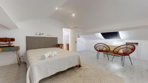 Un dormitorio con una cama y dos sillas y una mesa. en Azores Calheta Inn Apartment T3, en Ponta Delgada