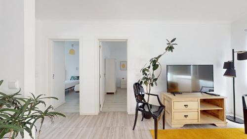 a room with a desk and a tv and a chair at Azores Calheta Inn Apartment B 1ºDrto in Ponta Delgada