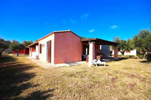 a dog walking in front of a small house at Villas with private pool in Costa Rei just 500 meters from the sea in Costa Rei