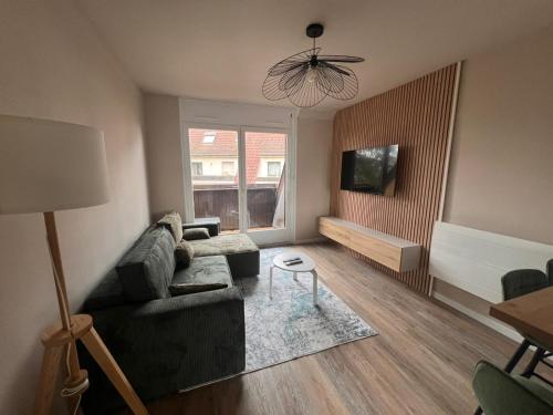 un salon avec un canapé et une table dans l'établissement NEW, Strasbourg T2 Neuf Proche Parlement, à Strasbourg