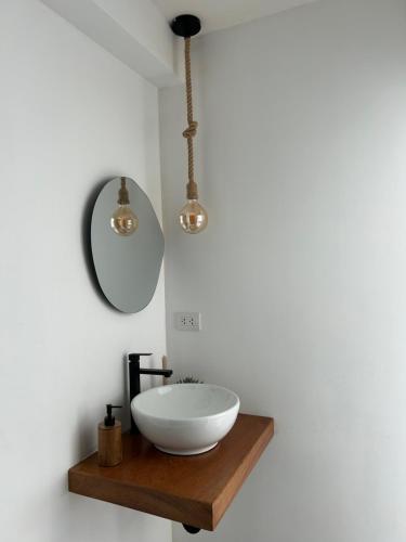a bathroom with a bowl sink and two lights at Wiracieneguilla in Cieneguilla