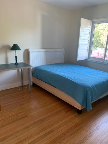 a bedroom with a bed and a desk and a window at RoomL in Hayward