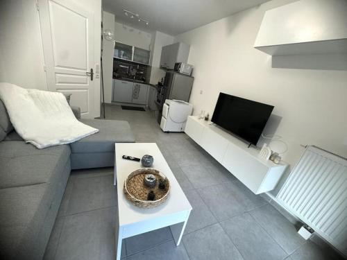 un salon avec un canapé et une télévision dans l'établissement Saphir Plage, à Roquebrune-Cap-Martin