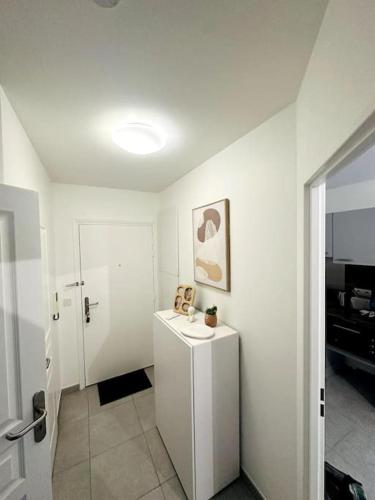 une salle de bain blanche avec un lavabo et un miroir dans l'établissement Saphir Plage, à Roquebrune-Cap-Martin