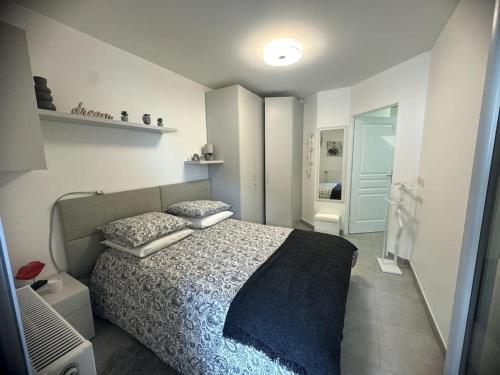 une chambre avec un lit avec une couette bleue dans l'établissement Saphir Plage, à Roquebrune-Cap-Martin