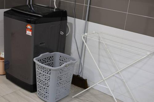a trash can sitting next to a wall with a basket at JB 19pax Premium Skudai Party House in Skudai