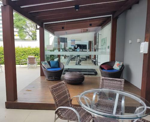 a living room with a glass table and chairs at GoldMen Business Joinville in Joinville