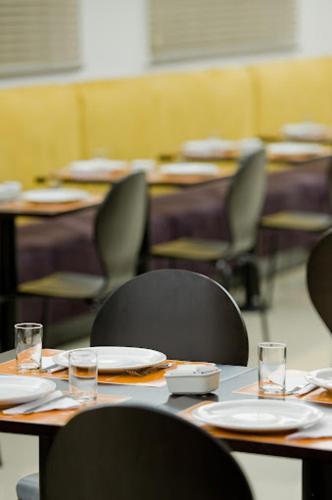 a group of tables with chairs and plates on them at GoldMen Business Joinville in Joinville