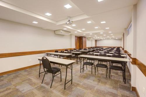 a classroom with tables and chairs in a room at GoldMen Business Joinville in Joinville