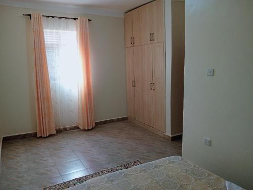 an empty room with a window and some cabinets at Royal Stay in Kira