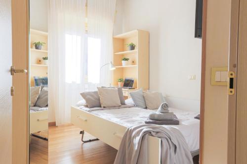 a bedroom with a bed with white sheets and a window at Il Rifugio di Greta in Ceparana