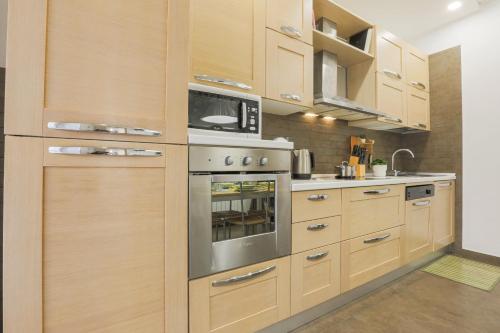a kitchen with wooden cabinets and stainless steel appliances at Il Rifugio di Greta in Ceparana
