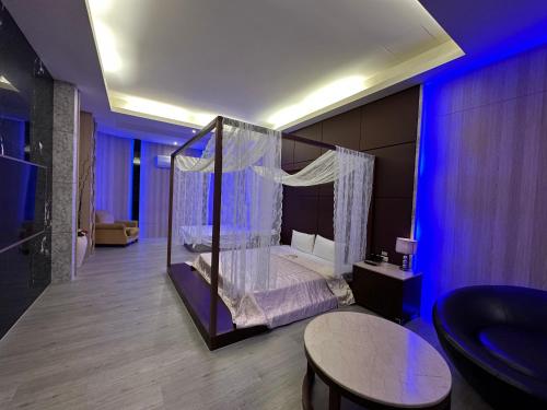 a bedroom with a canopy bed in a room at 亞曼尼汽車旅館-頭份館 in Toufen