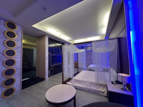 a bedroom with a bed and a table and a stool at 亞曼尼汽車旅館-頭份館 in Toufen