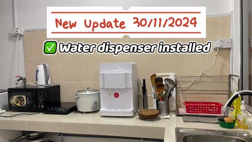a kitchen counter with a water dispenser on it at Desaru beach waterpark Tvbox By Joyfully 20b10 in Desaru
