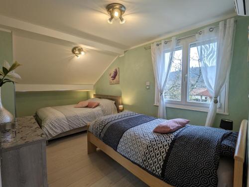 una camera da letto con due letti e una finestra di Chalet spacieux avec sauna, spa et baby-foot, proche stations de ski - FR-1-589-671 a Ramonchamp