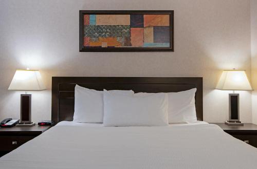 a bed in a hotel room with two lamps at Travelodge by Wyndham Kamloops Mountview in Kamloops