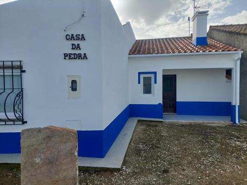 a white and blue building with a sign on it at Casa da Pedra in Cabeça de Carneiro