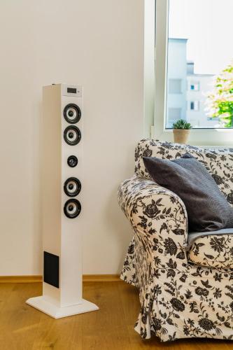 a living room with a speaker next to a couch at Bregenzer Traum am Bodensee inkl Fahrräder in Bregenz