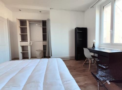 une chambre avec un grand lit blanc et un bureau dans l'établissement Logement de charme proche centre-ville - TV - WiFi, à Dijon