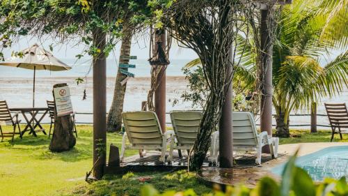 a group of chairs and an umbrella next to a pool at Hotel Porto do Zimbo in Morro de São Paulo