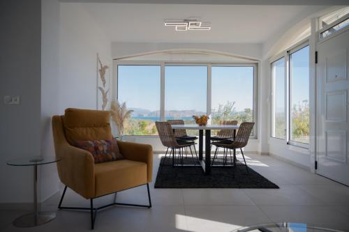 a living room with a table and chairs and a window at Elysian Garden Villa in Míloi