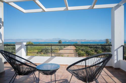 a view from the balcony of a house with two chairs at Elysian Garden Villa in Míloi