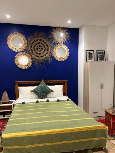 a bedroom with a bed with blue walls and mirrors at Art riad au bord de la mer 1 in El Jadida