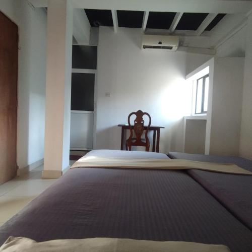 a large bed in a room with a chair at Glance Beach Ahangama in Ahangama