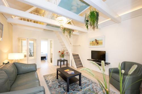 a living room with a couch and a tv at Mesdag apartment in Scheveningen