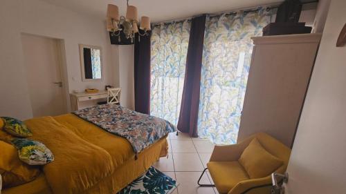 a bedroom with a bed and a chair and a window at Les Ducs Ô Calme de Nevers in Nevers