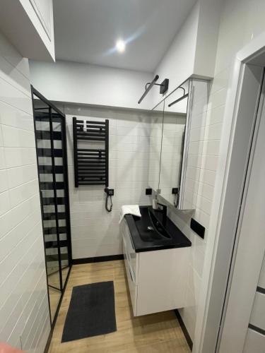 a bathroom with a black sink and a mirror at Apartamenty Tychy Czysta 33 in Tychy